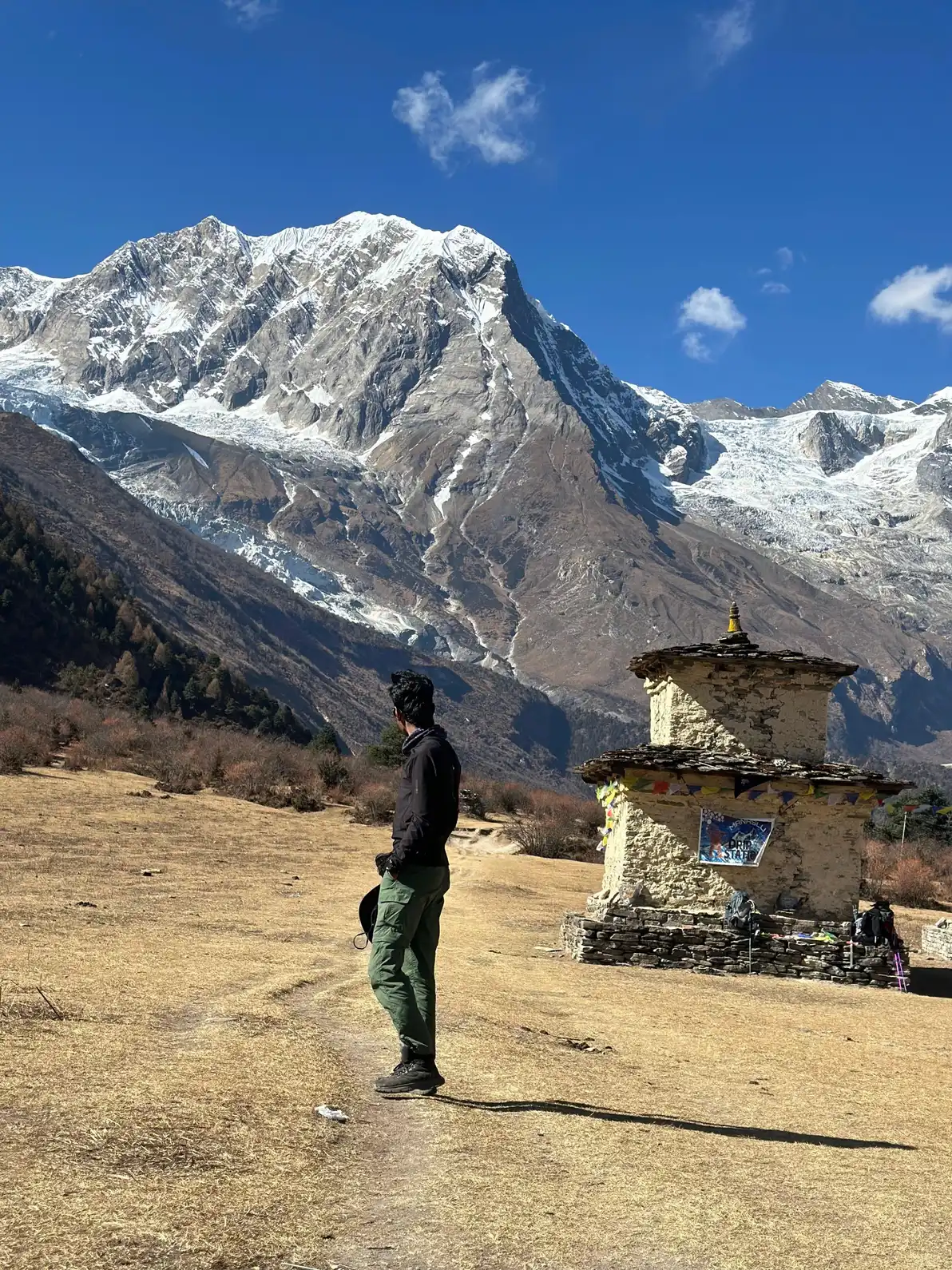 Trekker beside a chorten above Samagaun, below the north face of Manaslu